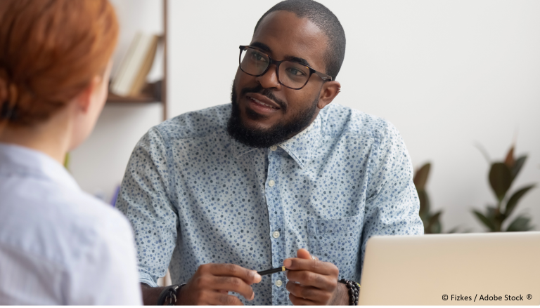 2 personnes qui échangent autour d'un bureau